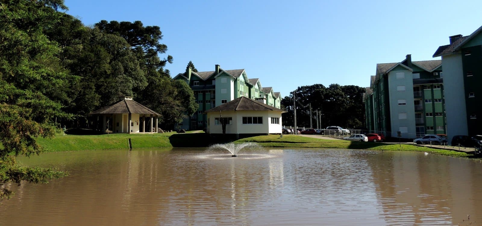 Lago do condomínio com o quiosque e os edifícios ao fundo